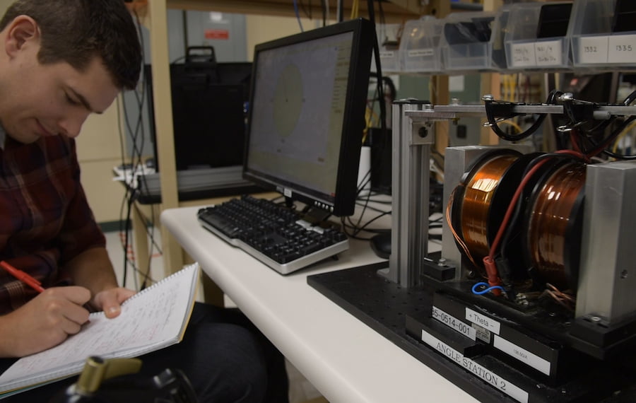 Employee in a lab writes in notebook